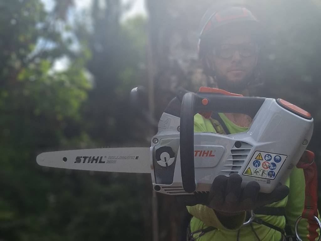 Krisztián egy motoros STIHL fűrészt tart a kezében